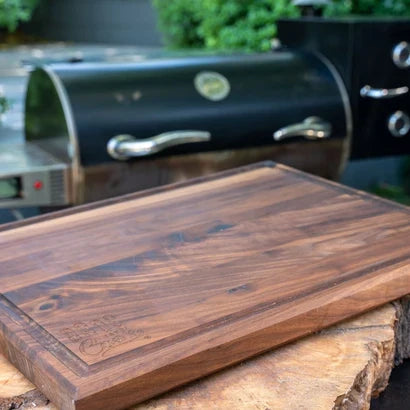 Knifz walnut cutting board on a rustic log slab outdoors